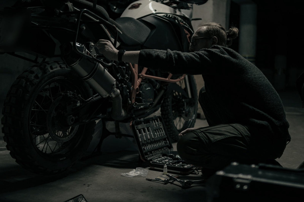 Motorista revisando su moto en un garaje. Foto: Angry._.Kat / Unsplash